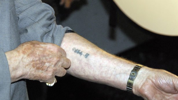 Holocaust - Überlebender zeigt seine Hand mit tätowierter Nummer