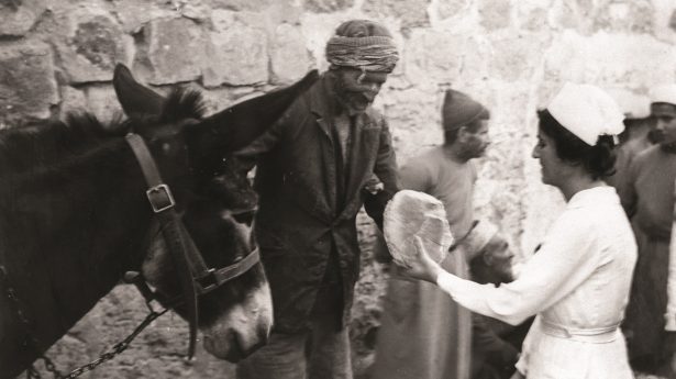 Jüdische Krankenschwester verteilt Brot an Araber in Jerusalem.