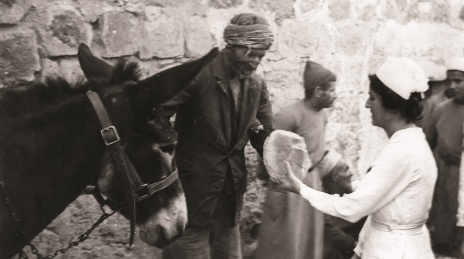 Jüdische Krankenschwester verteilt Brot an Araber in Jerusalem.