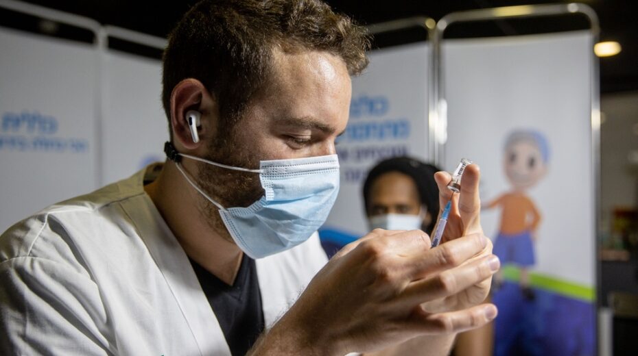 Israeli healthcare worker prepares a vaccine dose