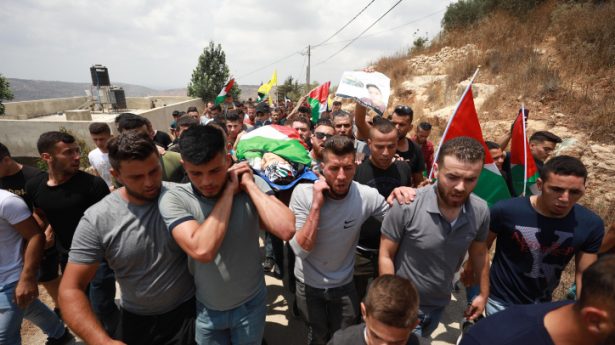 Palestinians carry the body of Mohammed Tamimi, 17, who was killed during clashes with Israeli security forces the previous day, during his funeral in the West Bank village of Deir Nizam, near Ramallah, July 24, 2021.