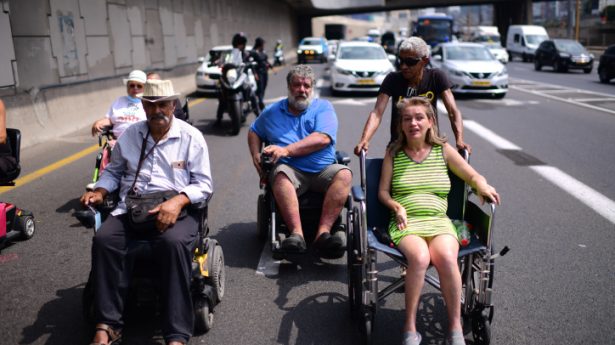 Disabled, handicapped and activists block the Ayalon Highway in Tel Aviv as they attend a protest calling for better health care on July 25, 2021.