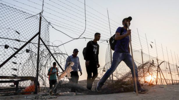 Palestinian workers cross into Israel through a hole in the security fence near the West Bank city of Hebron, July 25, 2021.