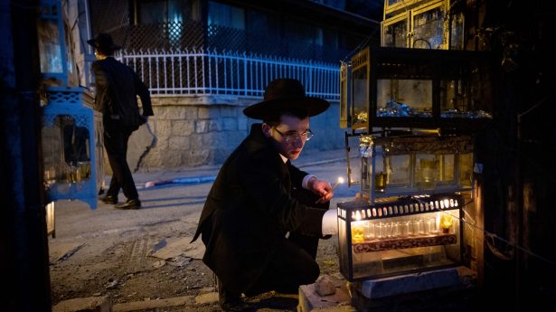 Ultra-Orthodox men light Hanukkah candles in the Jerusalem neighborhood of Mea Shearim.