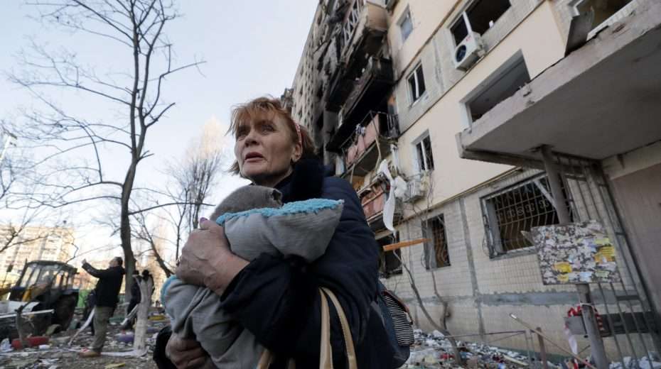 A Ukrainian women flees her bombed-out home following a Russian attack on Kyiv.
