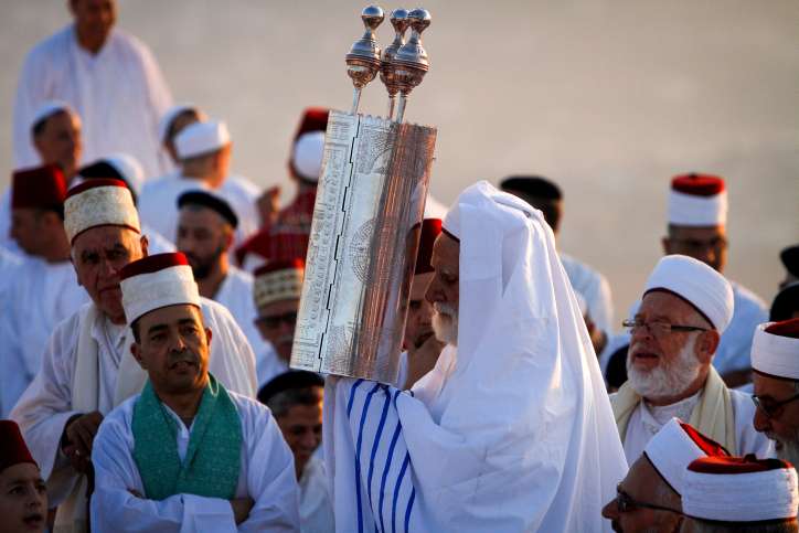Is There Such a Thing as a Good Samaritan? A Samaritan priest surrounded by worshippers holds up a Torah scroll on Mount Gerizim in Samaria.