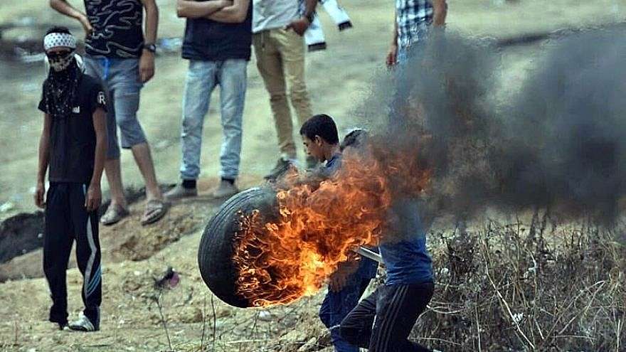 Palestinians burn tires to throw over the Gaza border into Israel on May 4, 2018, as part of weekly riots led by Hamas since March 30.
