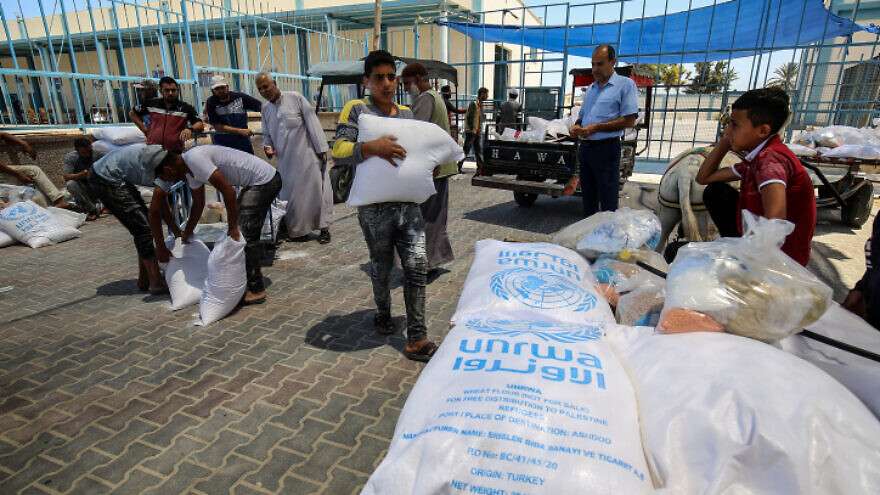 Palestinians receive food aid at an UNRWA distribution center in the southern Gaza Strip town of Rafah on May 26, 2021.