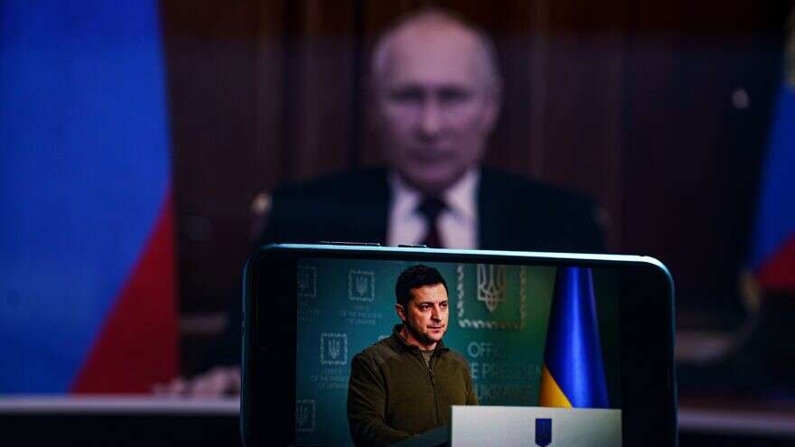 Is the Russian Threat to the Jewish Agency a Return to Soviet Oppression? Ukrainian President Volodymyr Zelensky on TV with Russian President Vladimir Putin in the background, March 7, 2022.