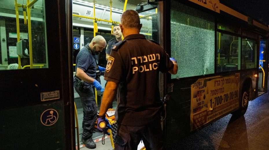 Police officers inspect a public bus after a terrorist opened fire on it in Jerusalem's Old City.