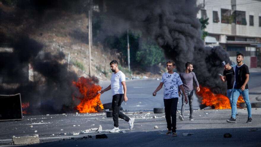 Palestinians hurl stones at Israeli soldiers in Nablus on August 17, 2022.