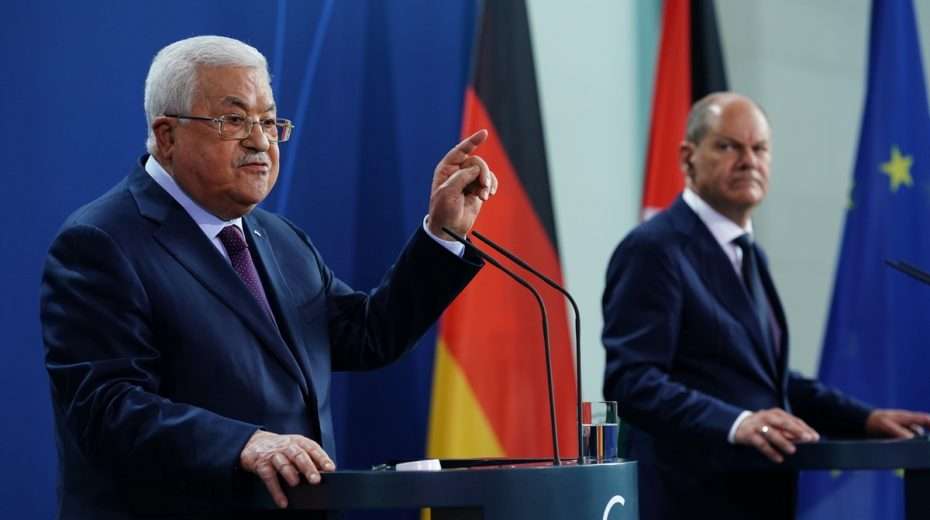 German Chancellor Olaf Scholz (right) grimaces as Palestinian leader Mahmoud Abbas accuses Israel of committing "holocausts" from the podium of the Federal Chancellery in Berlin.