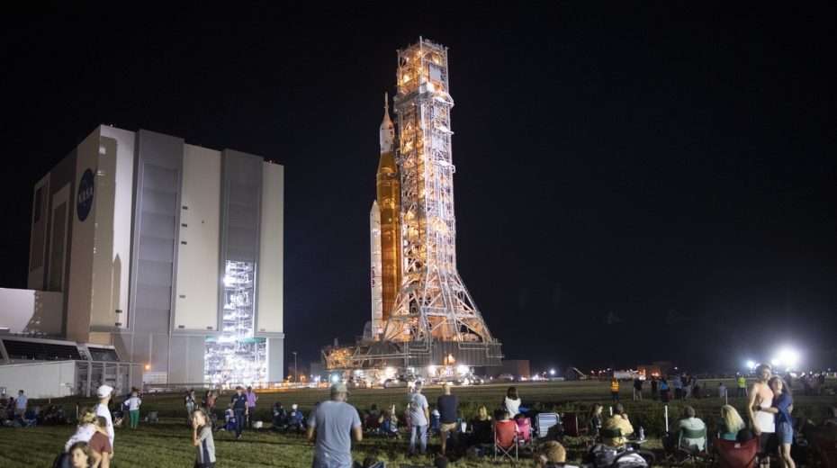 Gäste und NASA-Mitarbeiter beobachten, wie die Artemis I-Rakete vor dem Start nächste Woche zur Startrampe gerollt wird.