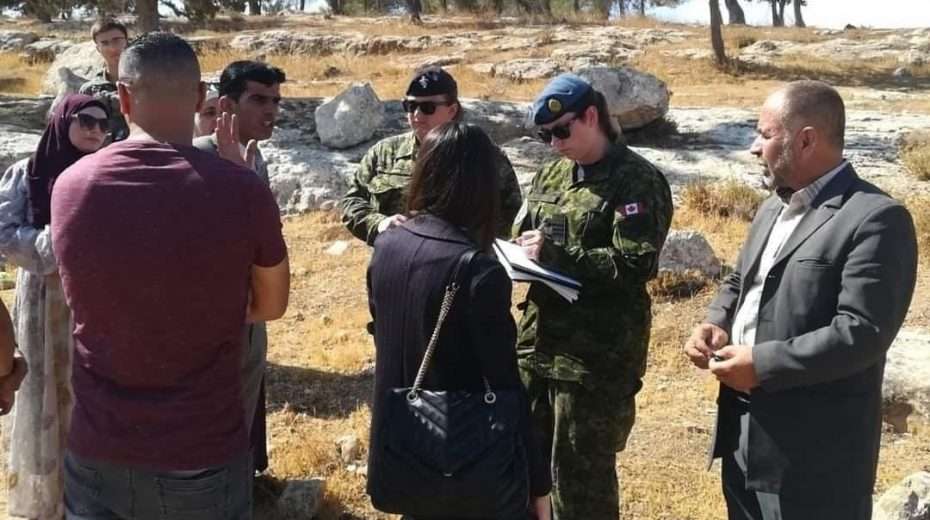Uniformed Canadian soldiers helping Palestinian officials survey land they have no authority over.