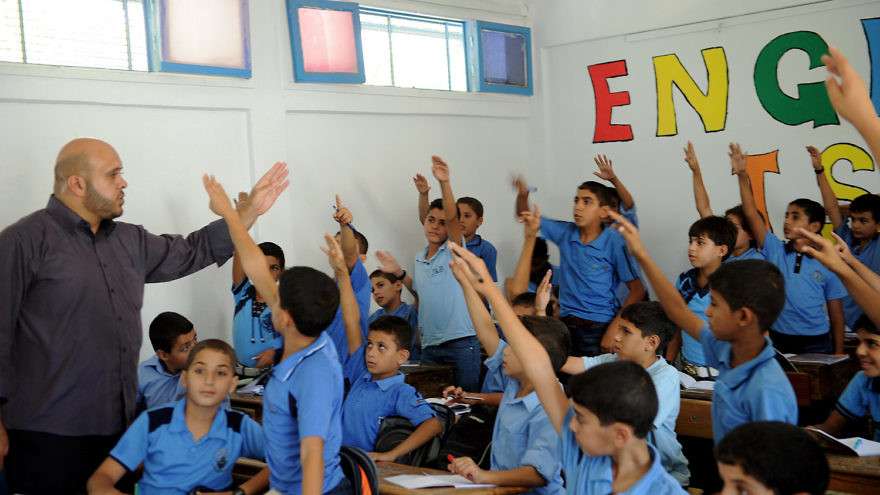 Palestinian boys raise their hands at a school in the Gaza Strip supported by the United Nations Relief and Works Agency for Palestine Refugees in the Near East (UNRWA) in September 2011. Credit: U.N. Photo/Shareef Sarhan.