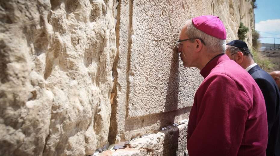 Archbishop of Canterbury Jonathan Welby prays at the Western Wall (in 2017), but is apparently too afraid of upsetting the Palestinians to affirm Jewish sovereignty over the city of Jerusalem.