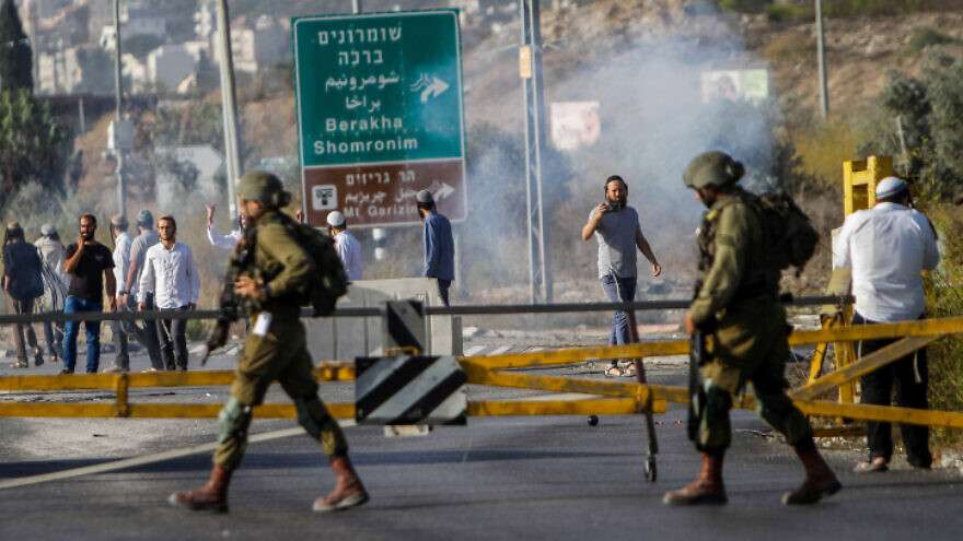 Jewish settlers clash with Israeli security forces during a protest at the Hawara checkpoint, south of Nablus on October 4, 2022.