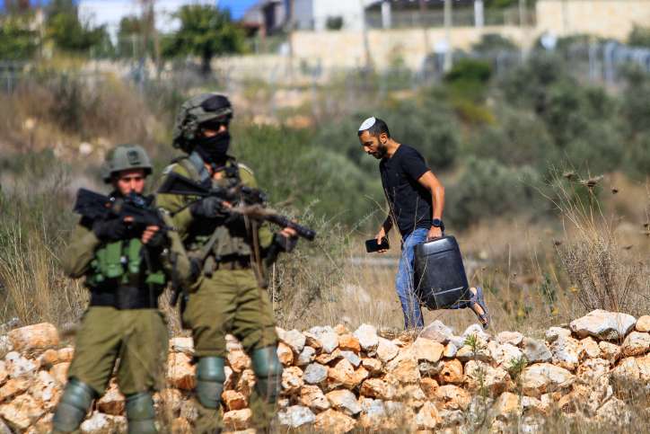 Israelische Soldaten halten Wache, während Palästinenser gegen jüdische Siedler protestieren, die Bäume pflanzen