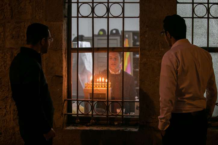 Orthodoxe jüdische Männer zünden die Kerzen für den jüdischen Feiertag Chanukka im Jerusalemer Stadtteil Mea Shearim an.