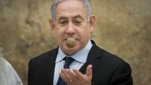 Prime Minister Benjamin Netanyahu handles an ancient artifact, yet further evidence of the Jews' long history in this land, during a ceremony in Jerusalem.
