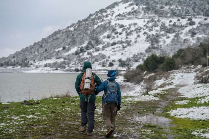 Wetter in Israel: Spaziergänger wandern im Schnee in der Nähe der heißen Quelle am Bental-Wasserreservoir auf den Golanhöhen