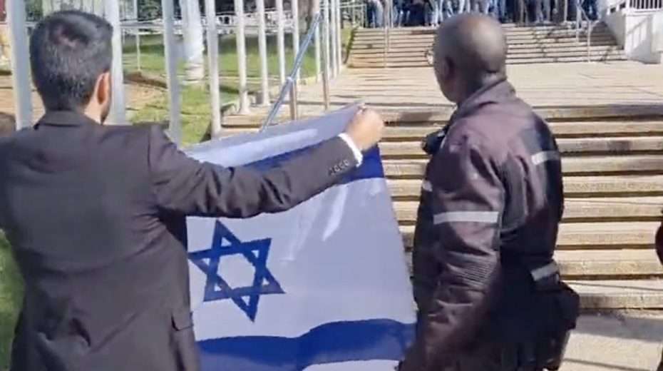 Der christlich-arabische Israeli, Yosef Haddad, entrollt eine israelische Flagge, als er muslimischen Studenten an der Universität Tel Aviv gegenübersteht.