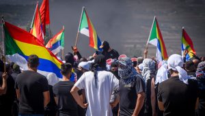 Druze protest while police guard during a protest against the construction of a new wind farm in the Druze village of Mas'ada, in the Golan Heights, June 21, 2023. Photo by Ayal Margolin/Flash90