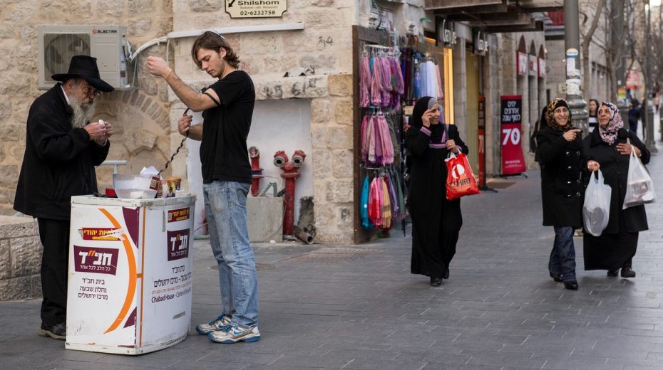 Secular Israelis Target Jewish “Missionaries” A Chabad representative convinces a young secular Israeli to pray in public. Some see this as "dangerous missionary activity." Photo by Danielle Shitrit/FLASH90