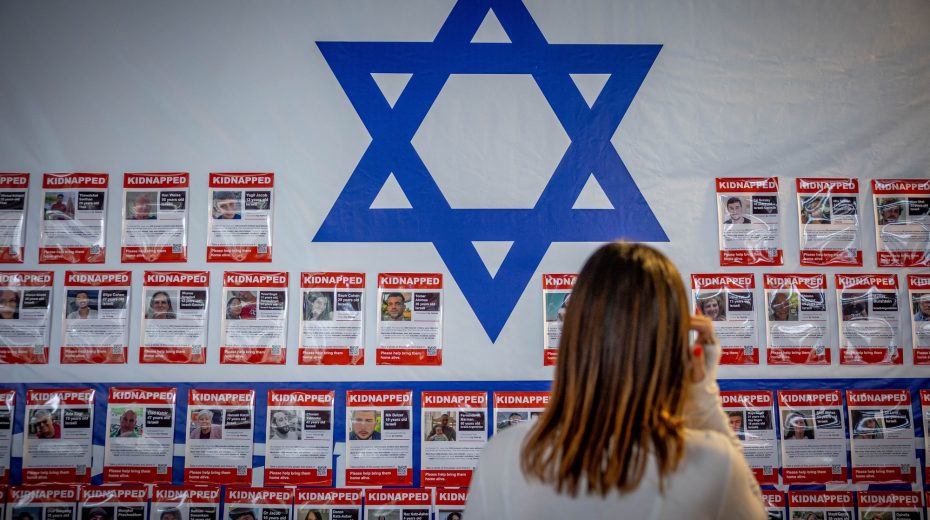 People walk next to pictures of civilians held hostage by Hamas terrorists in Gaza, in Jerusalem, November 22, 2023. Photo by Yonatan Sindel/Flash90