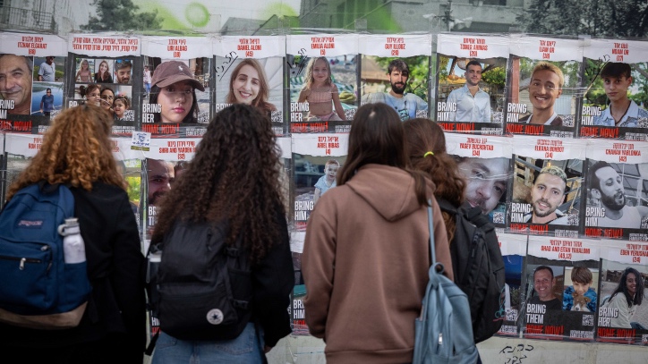People walk next to pictures of civilians held hostage by Hamas terrorists in Gaza, and some who were released in a deal between Israel and Hamas, in Jerusalem, November 22, 2023. Photo by Yonatan Sindel/Flash90