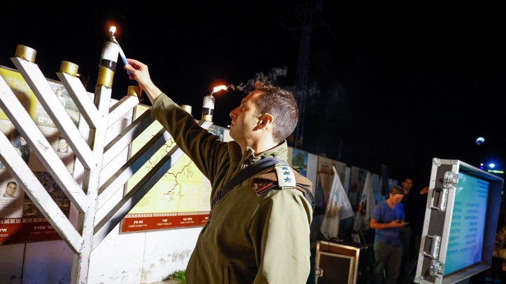 An IDF officer lights the Hanukkah menorah in Gush Etzion, south of Jerusalem. Photo by Gershon Elinson/Flash90