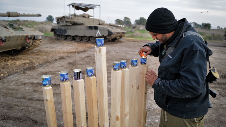 Israeli soldiers light candles on the second night of the Jewish holiday of Hanukkah, at a staging area near the Israeli border with Syria, on December 8, 2023. Photo by Michael Giladi/Flash90