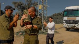 Israeli soldiers and civilians pray with a Torah scroll that survived the Holocaust at a rest area near the border with the Gaza Strip, December 21, 2023. Photo: Chen Schimmel/Flash90