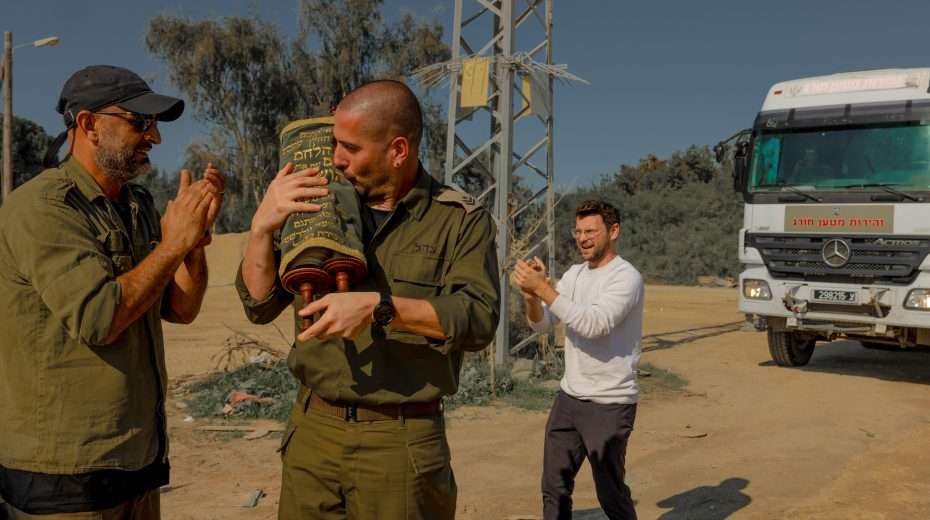 Israeli soldiers and civilians pray with a Torah scroll that survived the Holocaust at a rest area near the border with the Gaza Strip, December 21, 2023. Photo: Chen Schimmel/Flash90