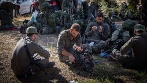 Israeli soldiers take a break before entering the Gaza Strip, Dec. 20, 2023. Photo by Yonatan Sindel/Flash90.