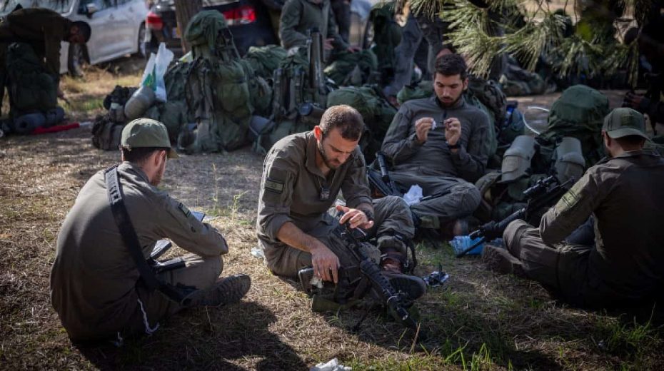 Israeli soldiers take a break before entering the Gaza Strip, Dec. 20, 2023. Photo by Yonatan Sindel/Flash90.