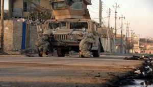 U.S. Army soldiers, attached to Heavy Company, 3rd Squadron, 3rd Armored Cavalry Regiment, take cover behind their vehicle as small-arms fire opens up in the distance in Mosul, Iraq, Jan. 17, 2008. Credit: Spc. Kieran Cuddihy/U.S. Army photo.