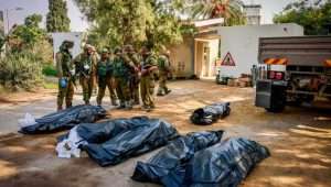 Israeli soldiers remove corpses in Kibbutz Kfar Aza, near the Gaza border, Oct. 10, 2023. Photo by Chaim Goldberg/Flash90.