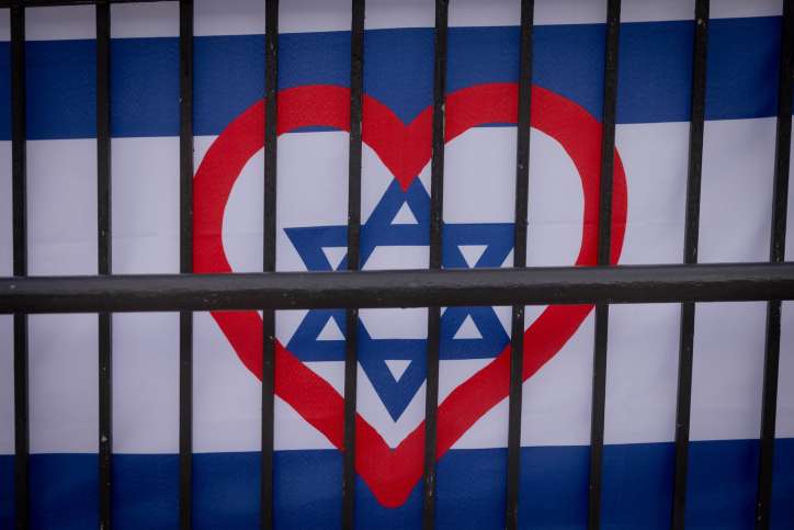 A heart seen painted on the Israeli flag, in Jerusalem. December 25, 2023. Photo by Chaim Goldberg/FLASH90