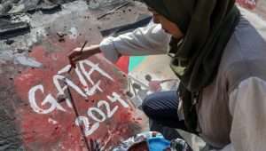 An Arab girl paints murals on the remains of a building in southern Gaza. Photo by Abed Rahim Khatib/Flash90