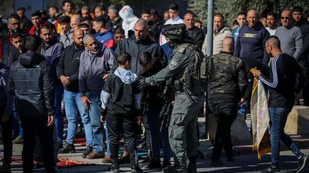 Israeli police guard while Palestinians perform Friday prayers in the eastern Jerusalem neighborhood of Ras Al Amud on Jan. 19, 2024. Photo by Jamal Awad/Flash90.