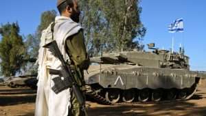 An Israeli soldier with a prayer shawl seen during a morning prayer near his tank near the border with Lebanon, northern Israel, October 25, 2023. Photo by Michael Giladi/Flash90