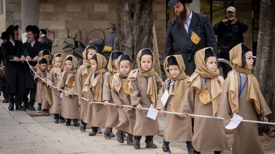 Jewish children from the Boyan Dynasty march before the Jewish festival of Purim in the Mea Shearim neighborhood of Jerusalem on March 18, 2024. Photo by Chaim Goldberg/Flash90