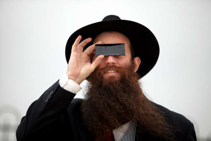 An Orthodox Jewish man watches a solar eclipse in Jerusalem on January 04, 2011. Photo by Abir Sultan/Flash90