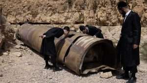 Haredi Jews examining the remains of a rocket fired from Iran, near the southern Israeli city of Arad, April 28, 2024. Photo by Oren Ziv/Flash90.