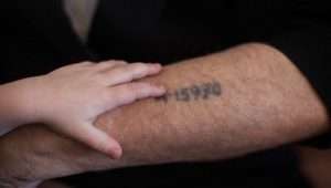 A Holocaust survivor shows his grandson the prisoner number tattooed on his arm, Jerusalem, May 24, 2013. Photo by Yonatan Sindel/Flash90.