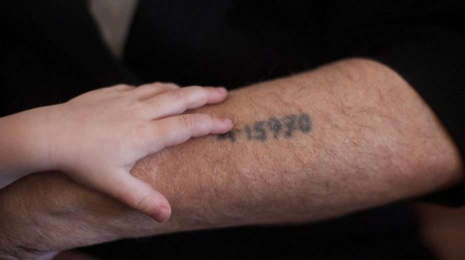 A Holocaust survivor shows his grandson the prisoner number tattooed on his arm, Jerusalem, May 24, 2013. Photo by Yonatan Sindel/Flash90.