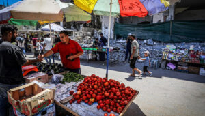 Palestinians shopping at a market next to destroyed buildings in Deir al-Balah, in the central Gaza Strip, May 31, 2024. Photo by Abed Rahim Khatib/Flash90