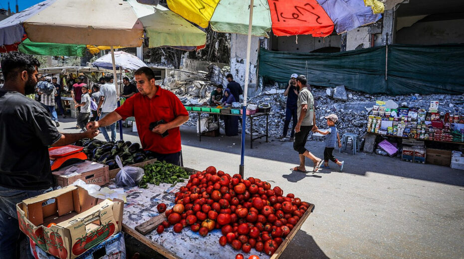 Palestinians shopping at a market next to destroyed buildings in Deir al-Balah, in the central Gaza Strip, May 31, 2024. Photo by Abed Rahim Khatib/Flash90