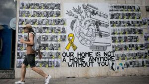 Israelis walk past a mural with photographs of Israelis held hostage by Hamas terrorists in the Gaza Strip since Oct. 7, in Tel Aviv, June 23, 2024. Photo by Miriam Alster/Flash90.